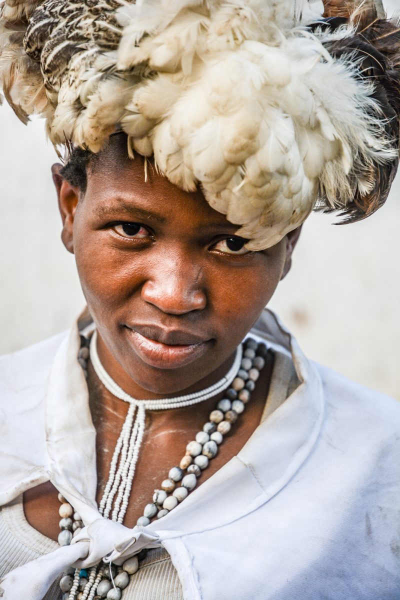 Twasa wearing her chicken feathers head piece, symbol of humility and service